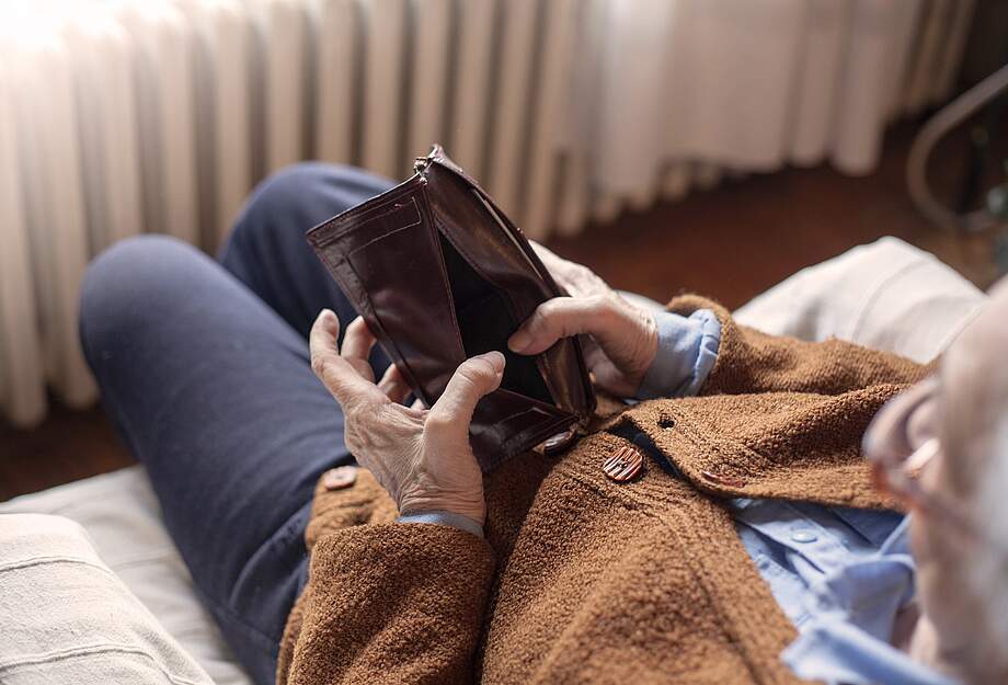 Une retraitée regarde son sac à main vide