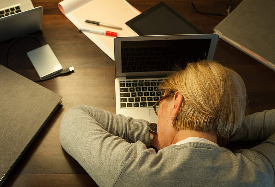 Une femme s'endort sur son ordinateur portable