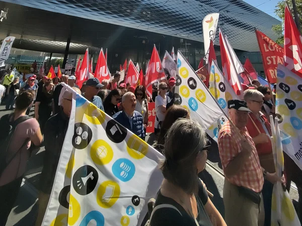 Des syndicalistes portant des drapeaux lors d’une manifestation.