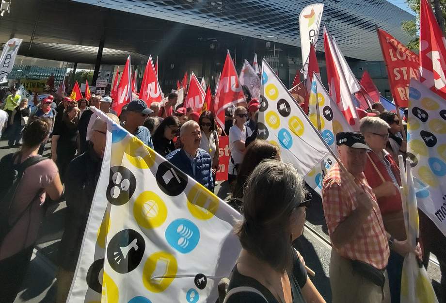 Des syndicalistes portant des drapeaux lors d’une manifestation.