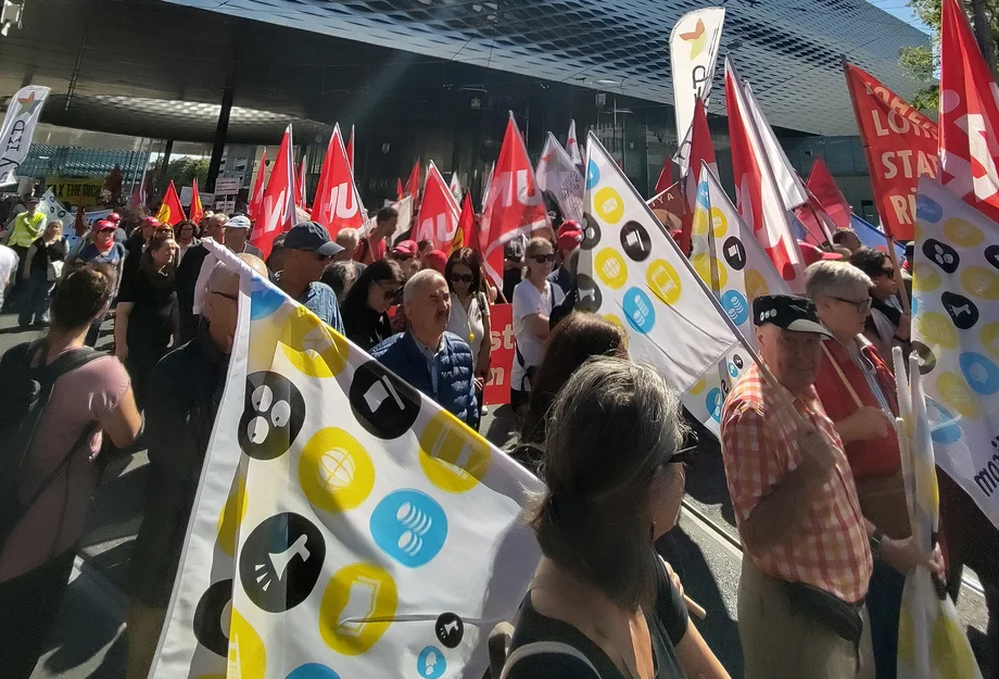 Des syndicalistes portant des drapeaux lors d’une manifestation.