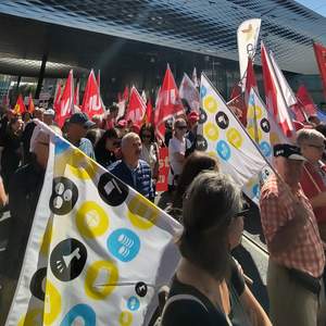 Des syndicalistes portant des drapeaux lors d’une manifestation.