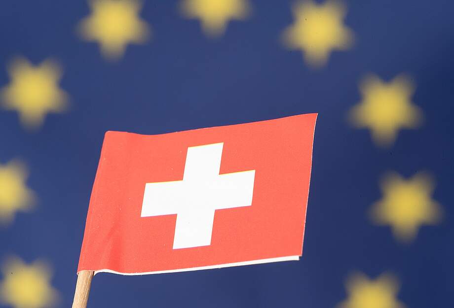 Le drapeau suisse devant le drapeau de l'UE