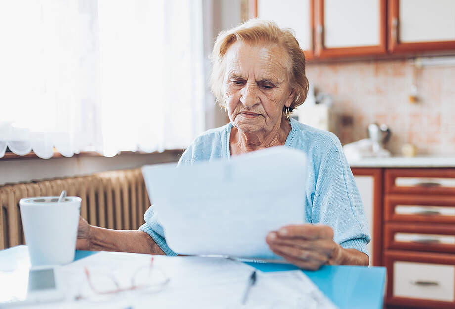 une femme agée avec beaucoup de factures