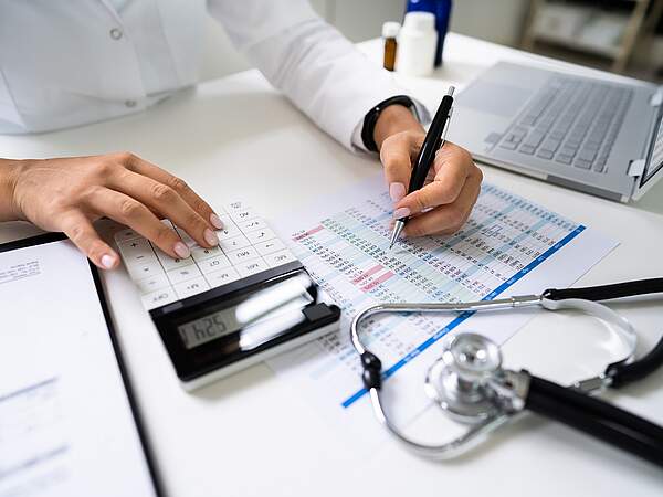 Une médecin qui calcule les statistiques et les coûts