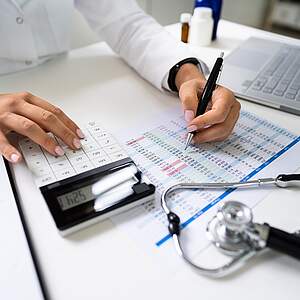 Une médecin qui calcule les statistiques et les coûts