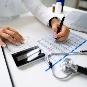Une médecin qui calcule les statistiques et les coûts