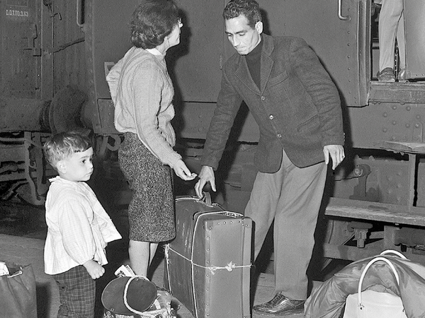 Famille de saisonnier à la gare avec des valises