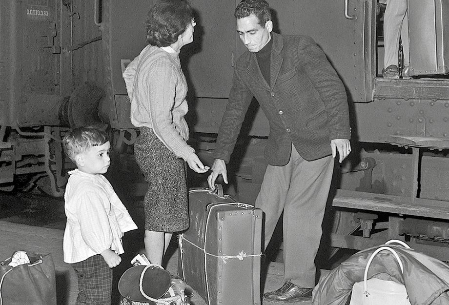 Famille de saisonnier à la gare avec des valises