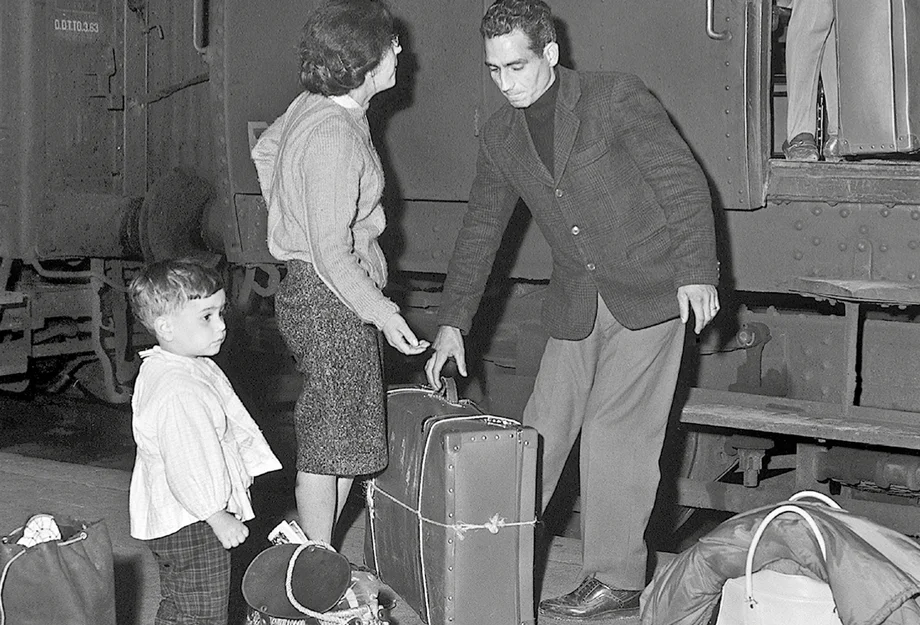 Famille de saisonnier à la gare avec des valises