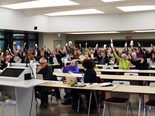 Les délégué-e-s de l’USS brandissent leurs bulletins de vote
