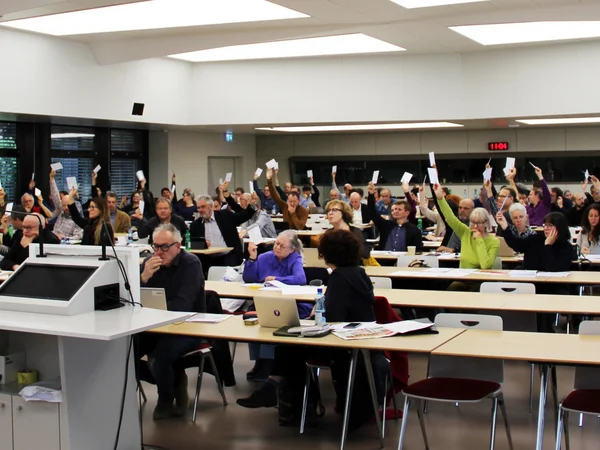 Les délégué-e-s de l’USS brandissent leurs bulletins de vote