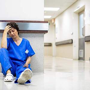 Une infirmière épuisée, allongée sur le sol