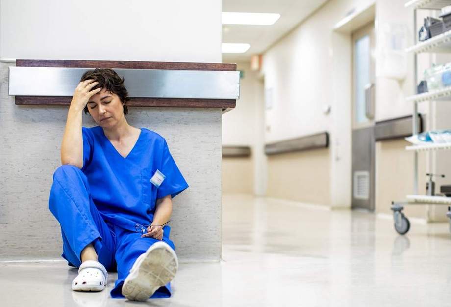 Une infirmière épuisée, allongée sur le sol