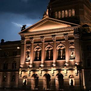 Le palais fédéral de nuit, avec des éclairs en arrière-plan