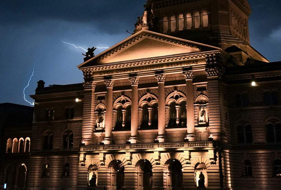 Le palais fédéral de nuit, avec des éclairs en arrière-plan