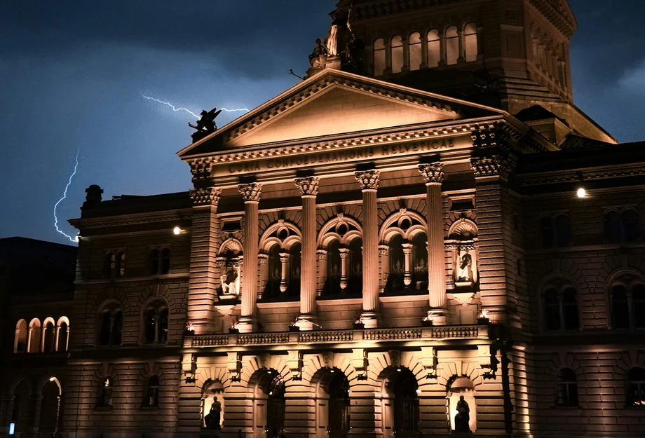 Le palais fédéral de nuit, avec des éclairs en arrière-plan