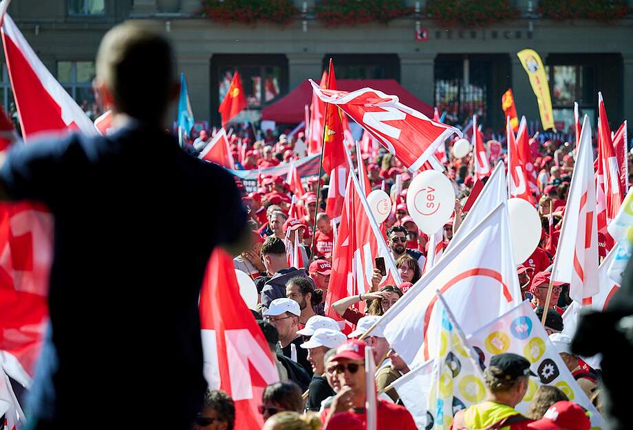 Des manifestants brandissent des drapeaux syndicaux.