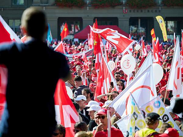 Des manifestants brandissent des drapeaux syndicaux.