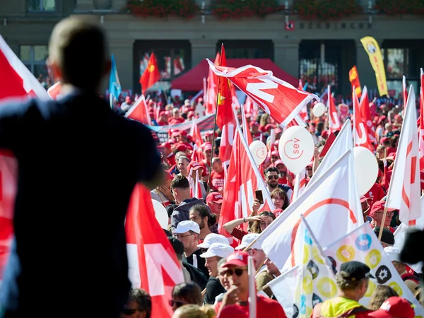 Des manifestants brandissent des drapeaux syndicaux.