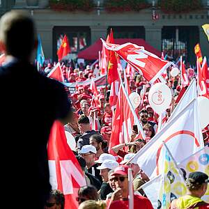 Des manifestants brandissent des drapeaux syndicaux.