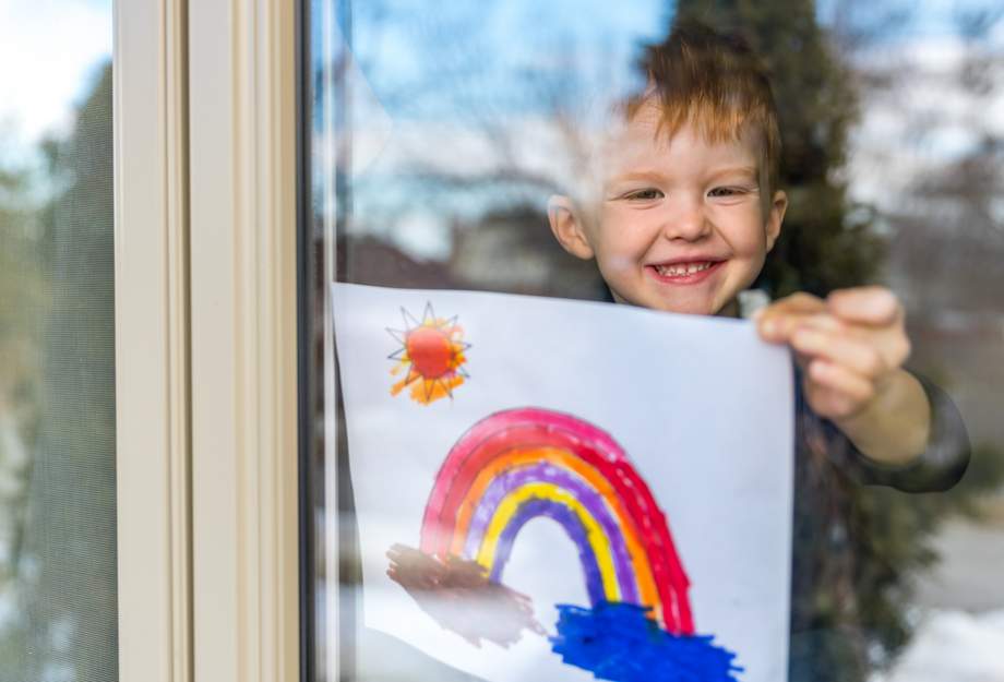 Coronavirus: Espoir Un garçon accroche un arc-en-ciel à la fenêtre