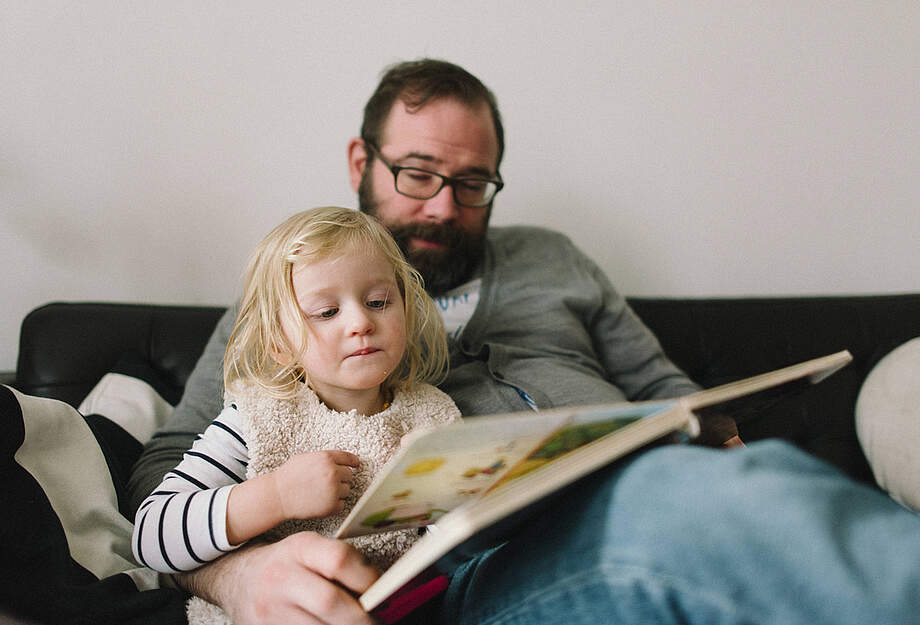 Un homme lit à un enfant.