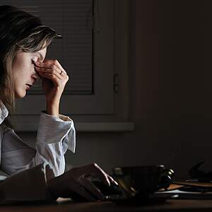 Femme épuisée devant l'ordinateur - après les heures supplémentaires