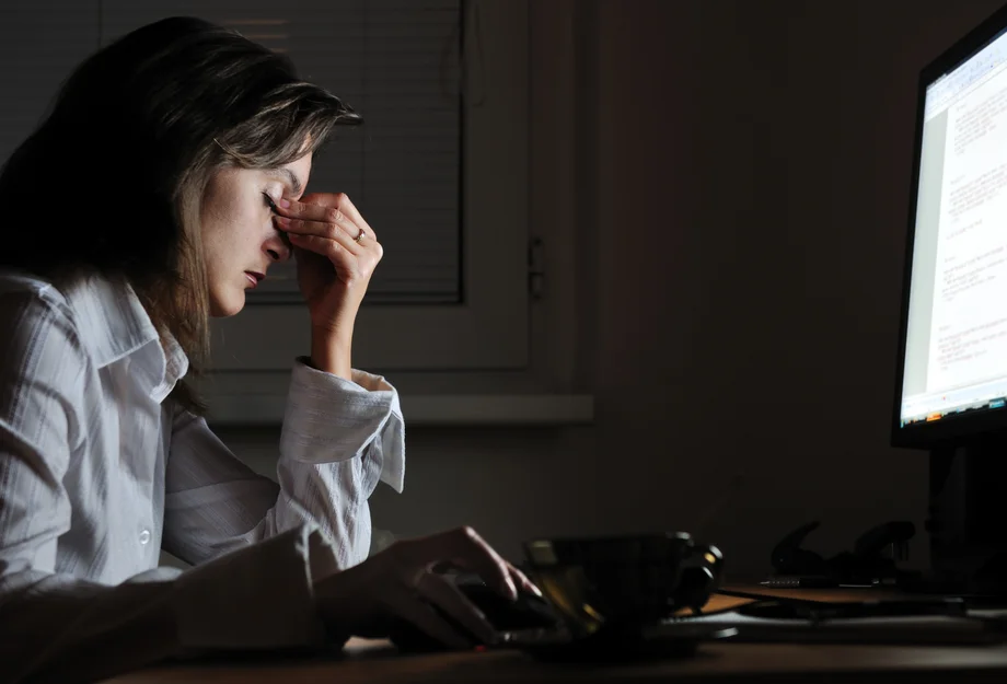 Heures supplémentaires Femme épuisée devant l'ordinateur - après les heures supplémentaires