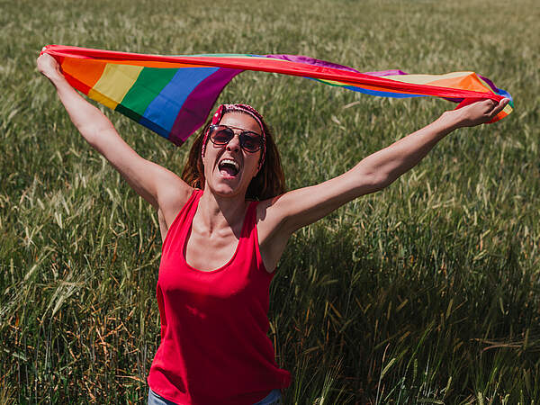 Femme avec drapeau arc-en-ciel