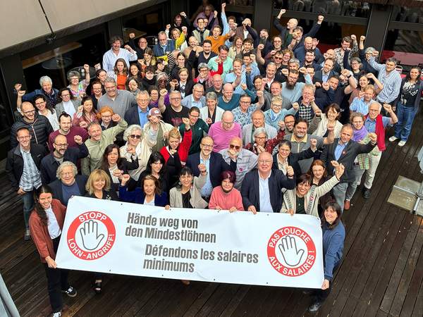 [Translate to Französisch:] Gewerkschafterinnen und Gewerkschafter halten ein Transparent gegen den Angriff auf den Mindestlohn