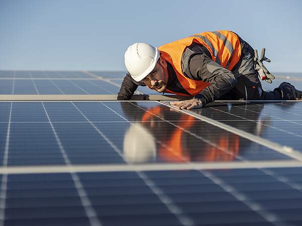 Un ouvrier contrôle une installation solaire sur le toit