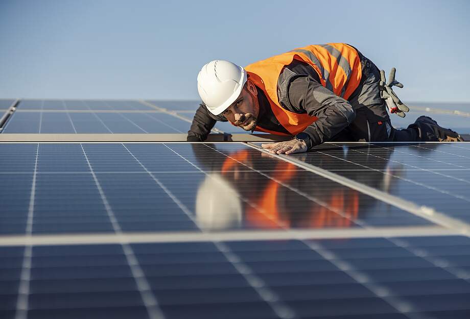 Un ouvrier contrôle une installation solaire sur le toit