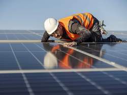 Un ouvrier contrôle une installation solaire sur le toit