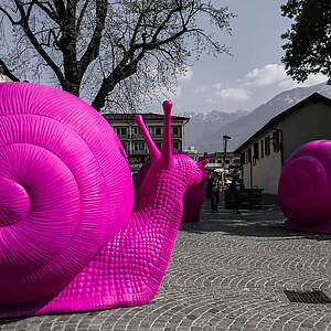 Photo d'une sculpture avec des escargots géants roses