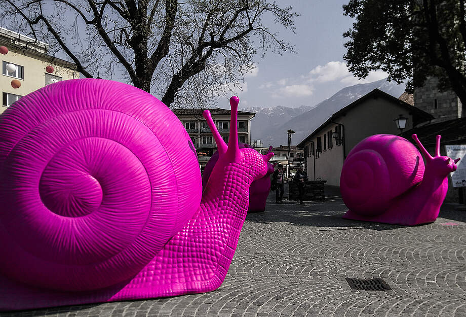 Photo d'une sculpture avec des escargots géants roses